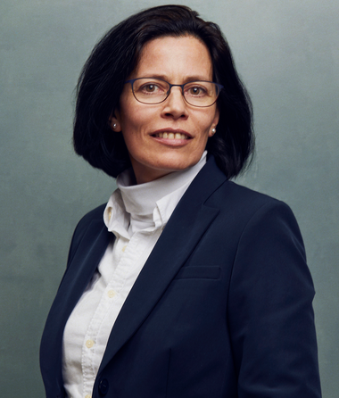 Meet the Team of experts - Photo of Caroline Verheyden, person in business suit, glasses with dark frames, smiling, female, friendly, standing upright